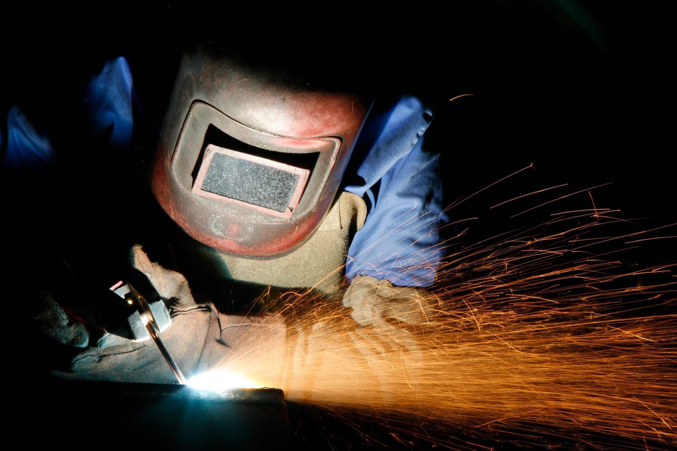 Welder with sparks on metal